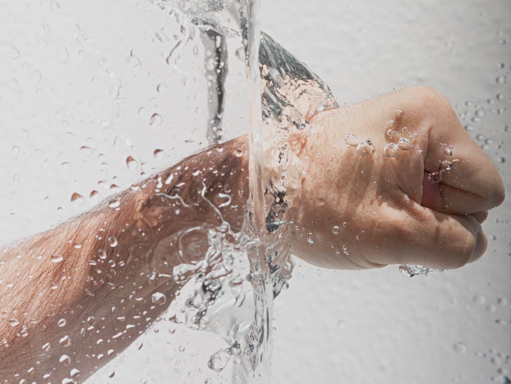 person s left fist punching water